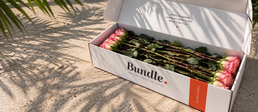 A Bundle. box beside an armful of flowers in a vase